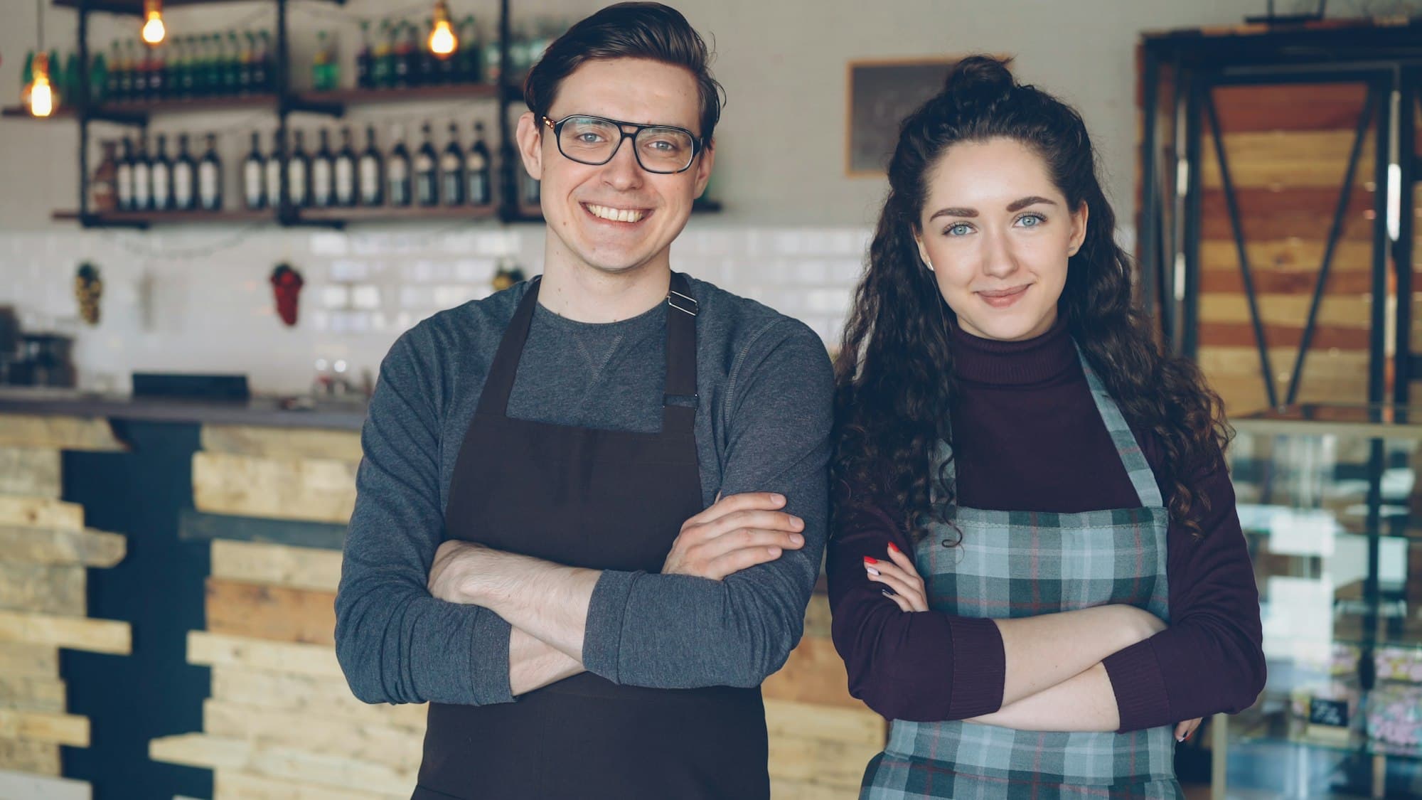 Deux propriétaires de café souriants devant leur comptoir